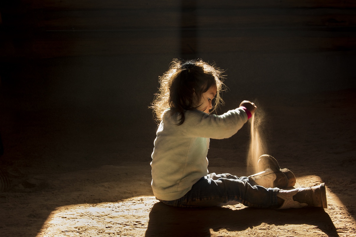 Small child playing on dirt in hogan
